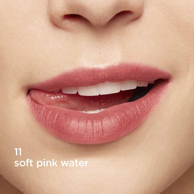 Gros plan sur des lèvres souriantes pour montrer la texture et la couleur de la teinte rose de l’eau à lèvres sur la carnation